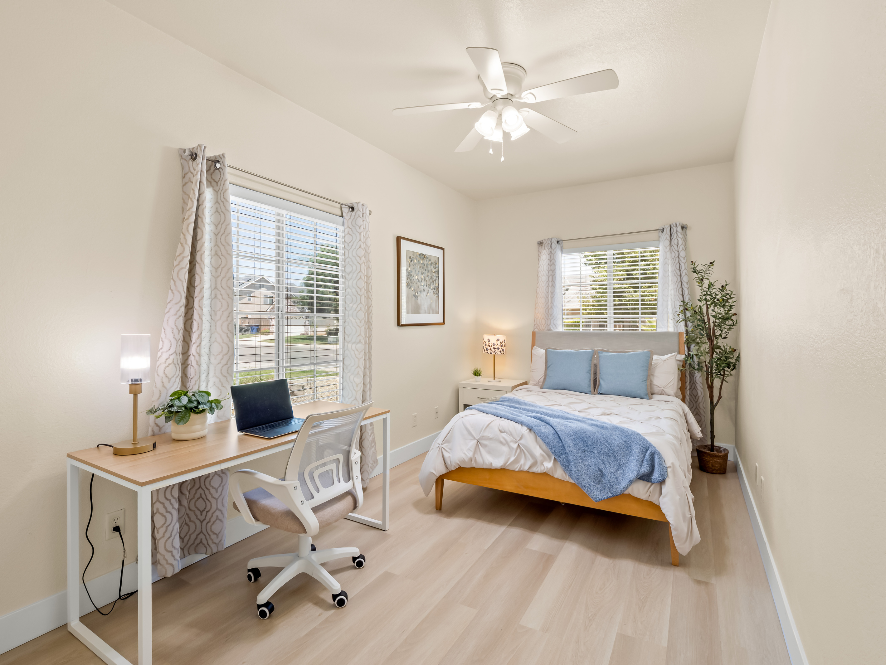 This bright and inviting bedroom offers a comfortable bed, abundant natural light, and a dedicated workspace, making it the perfect retreat for both relaxation and productivity during your stay.