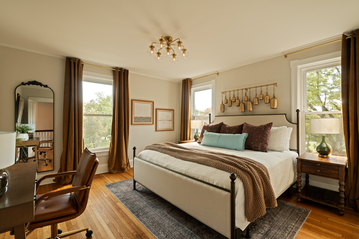 A bright and inviting bedroom with a king bed, beautiful natural light, and the character you’d expect from a thoughtfully updated 1900s home.