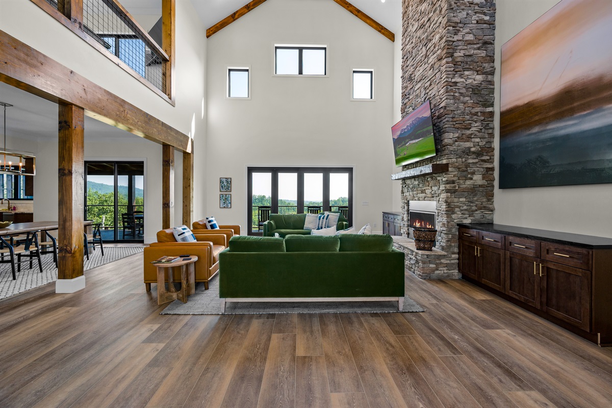 Living room with smart TV and floor to ceiling stacked stone gas fireplace.