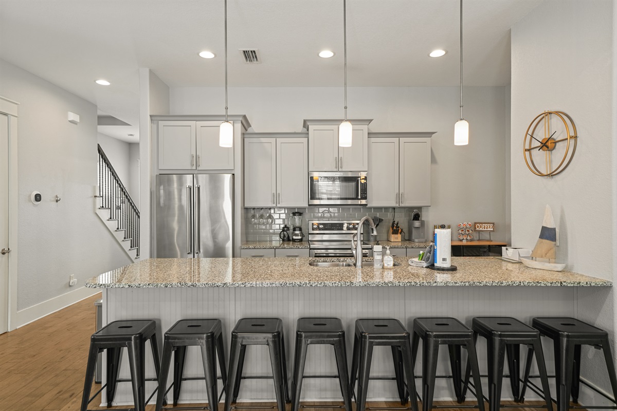 Open-concept kitchen featuring stainless steel appliances and generous island seating.