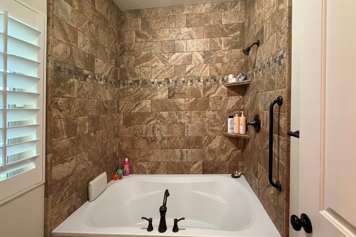 Relaxing soaking tub and stone shower combination perfect for unwinding after skiing or hiking adventures.