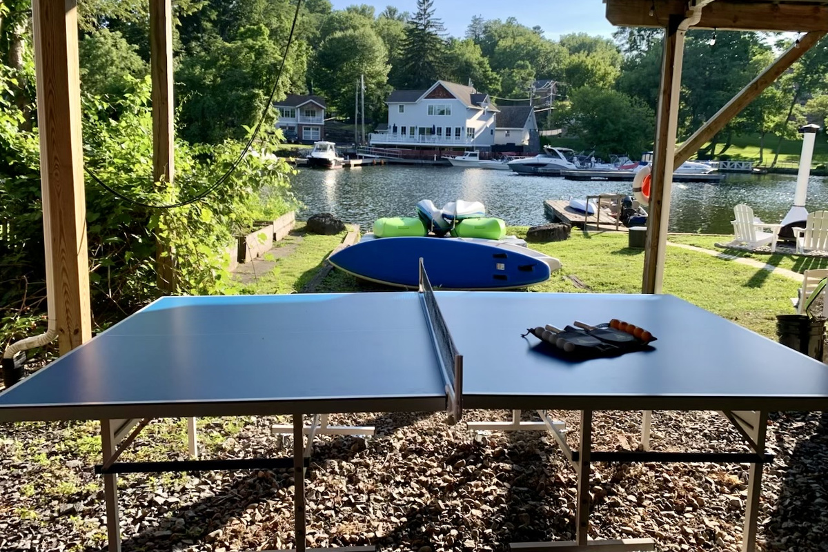 Covered outdoor ping pong with peaceful river views—perfect for family tournaments or a quick match between adventures.