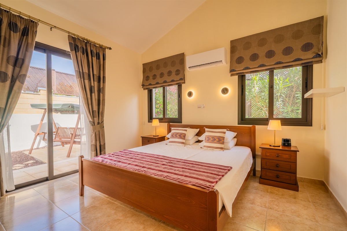 Second king bedroom with direct patio access. King size bed, ceiling fan, dedicated AC/heating unit, vanity, large built-in wardrobes, bluetooth speaker/alarm clock.