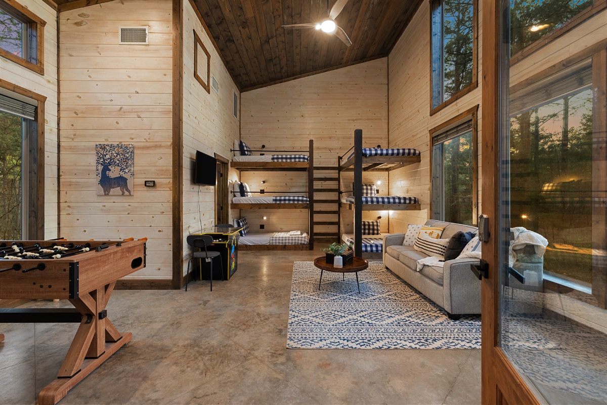 Challenge friends to foosball, spread out in the bunkhouse, and unwind with forest views and cozy cabin vibes all around.
