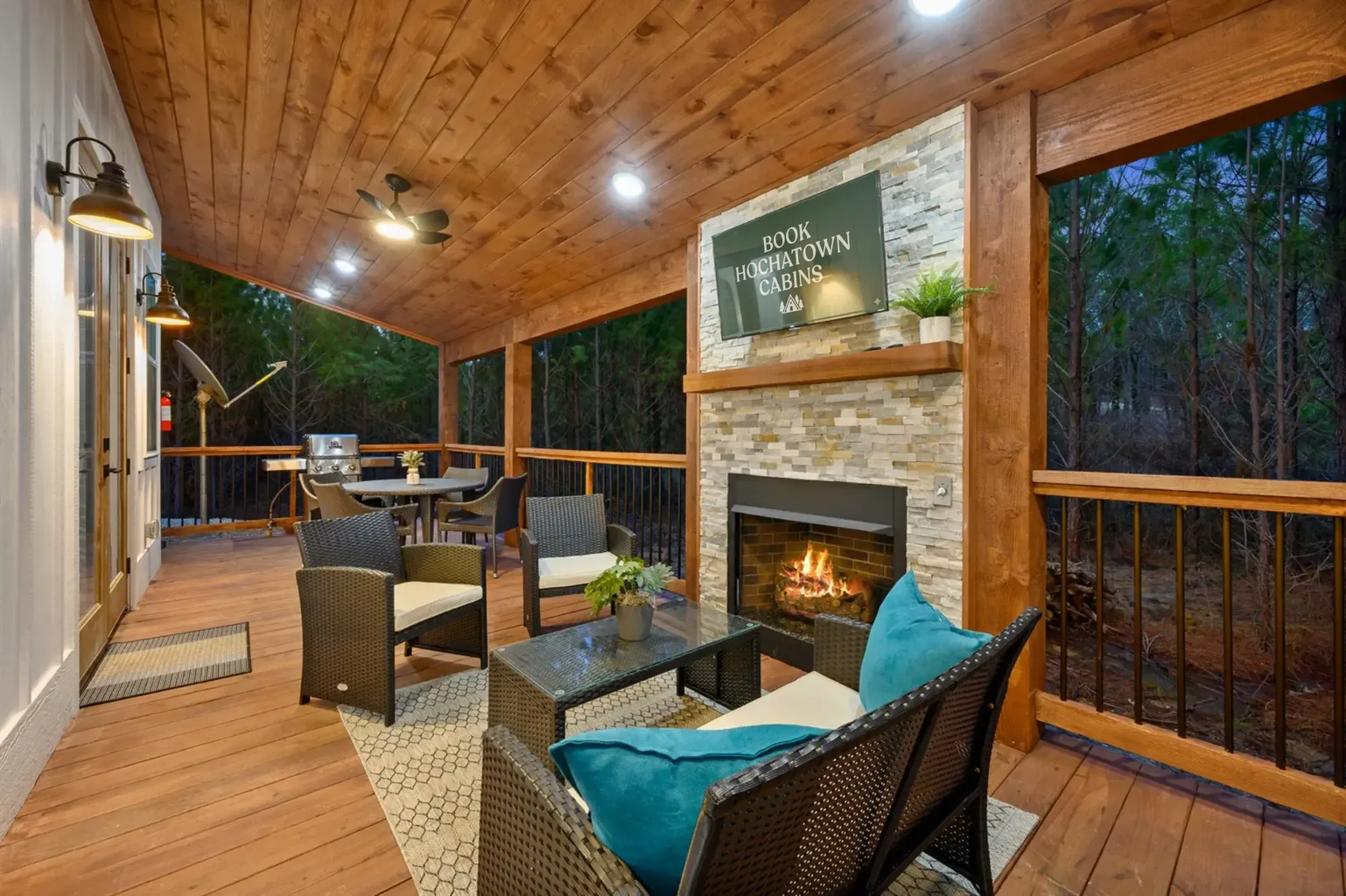Outdoor fireplace with TV and cozy seating for nights together