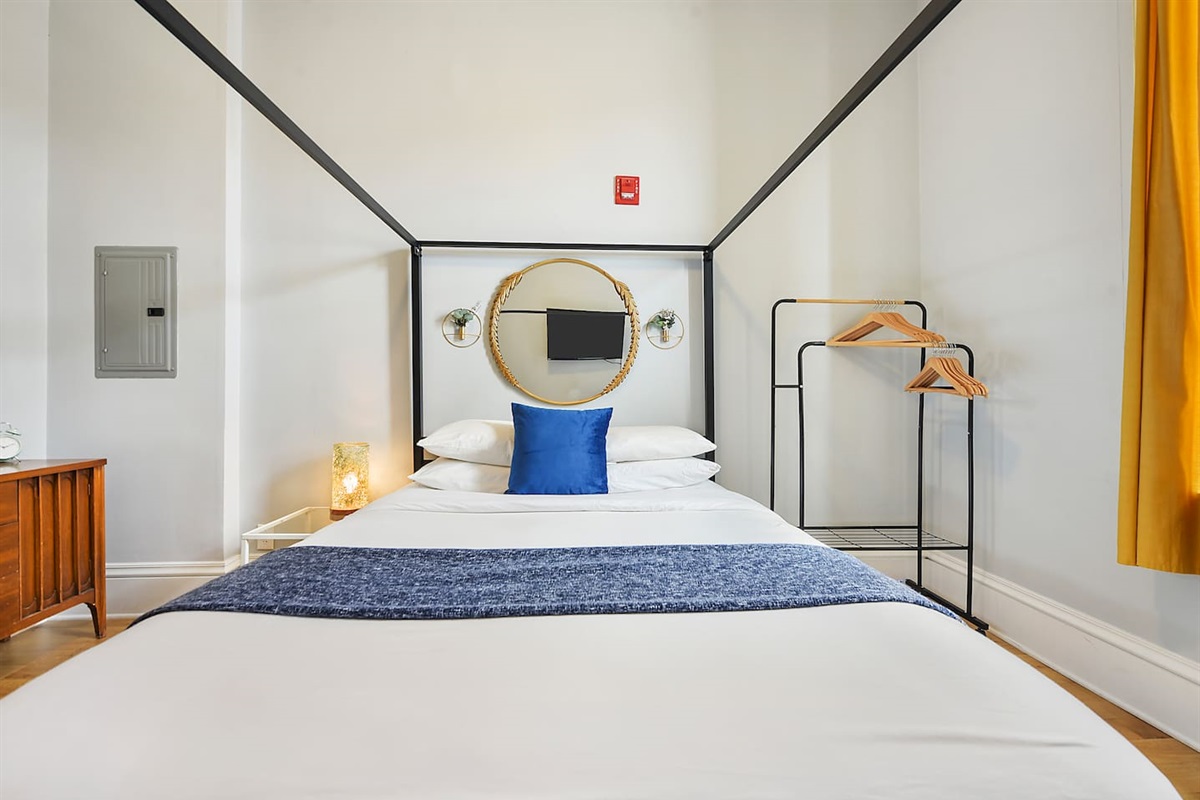 Cozy queen-sized bed with a unique frame and a TV for laid-back movie nights.
