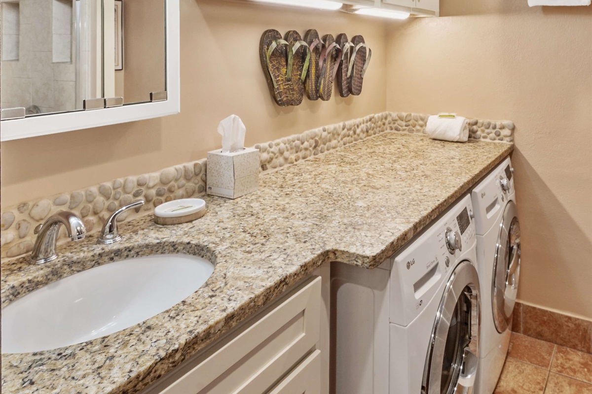 Main floor bathroom with shower, toilet, sink and washer/dryer