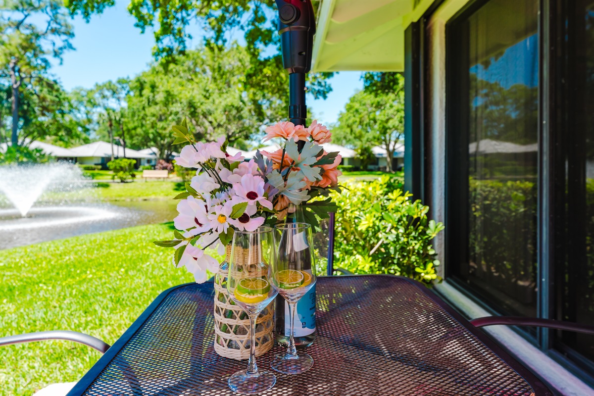 Private lakeside patio with outdoor dining, umbrella, and grill—perfect for morning coffee or sunset meals by the water
