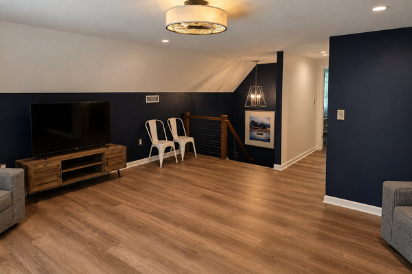 Relaxed upstairs loft with a large TV, open seating area and easy access to the upper-level bedroom, powder room and deck.