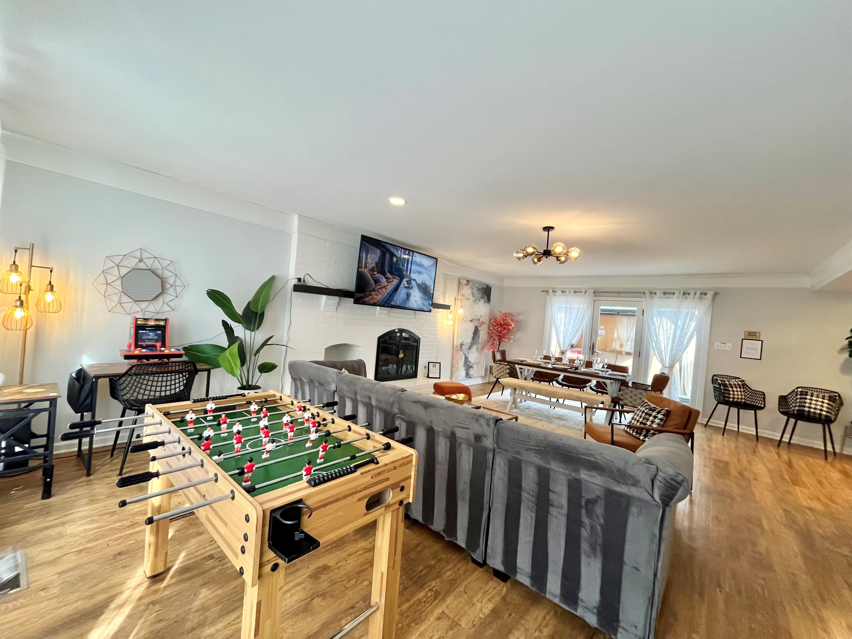 Spacious family room with fireplace and games and large patio door open door outdoor