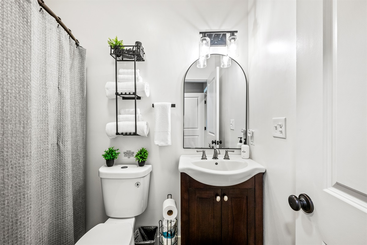 Fresh towels, thoughtful touches, and a full tub/shower combo make this lower-level bathroom as functional as it is stylish—perfect for guests staying in the downstairs bedroom with the King bed and Twin/Twin bunks. 