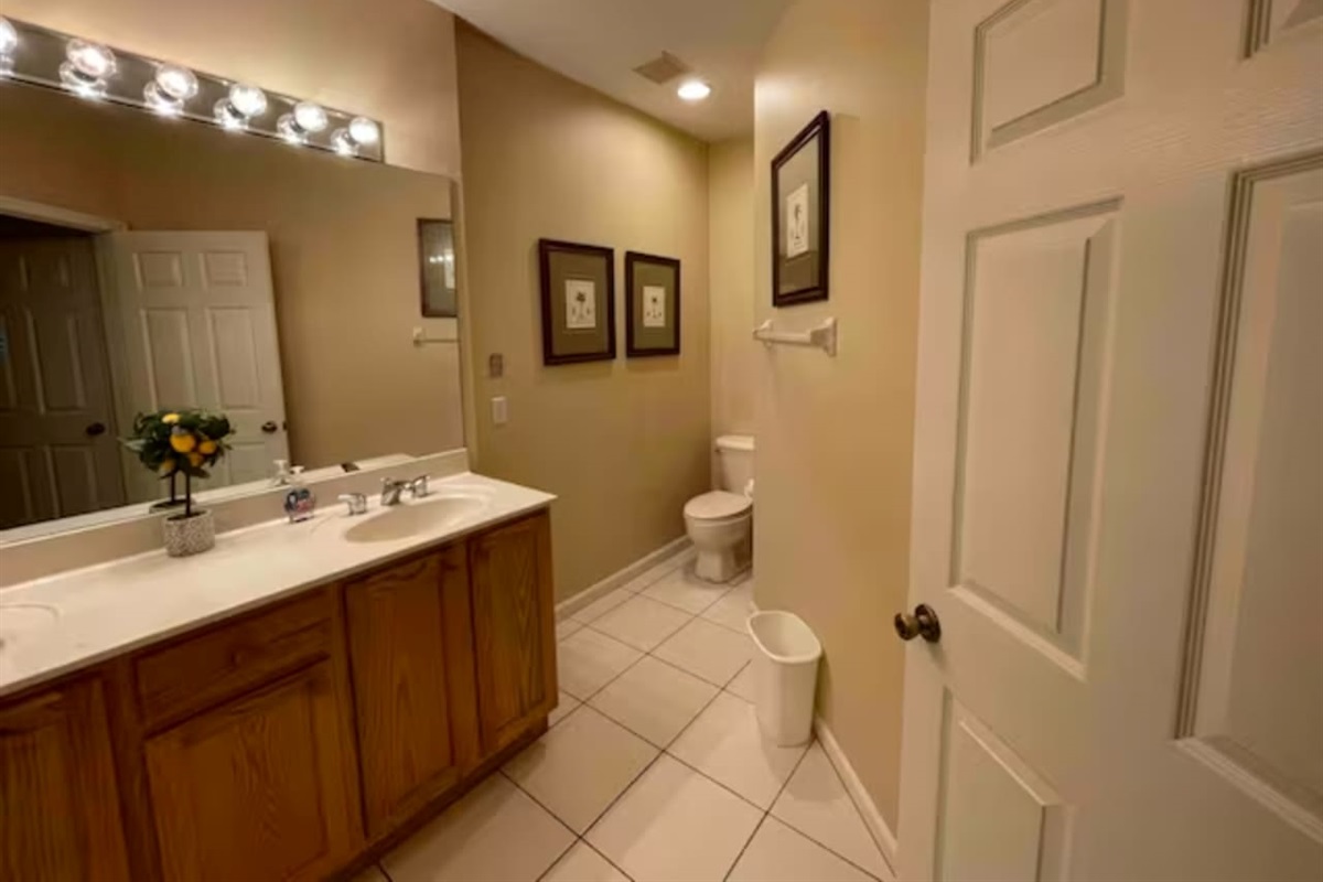 Spacious bathroom featuring a long vanity, tile flooring, and clean neutral finishes.