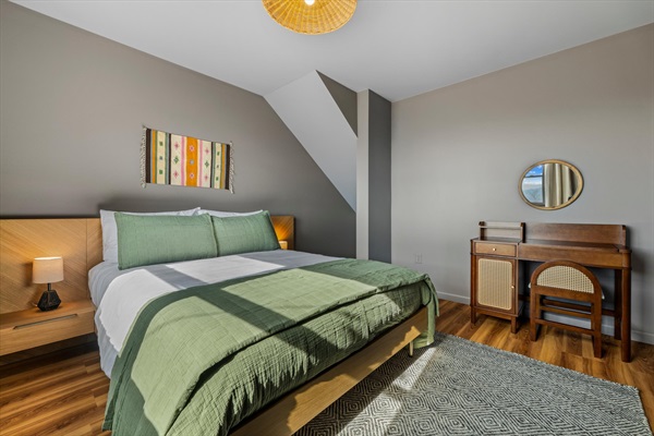 Light-filled queen bedroom with mountain views and a desk —ideal for relaxing, recharging, or staying connected.