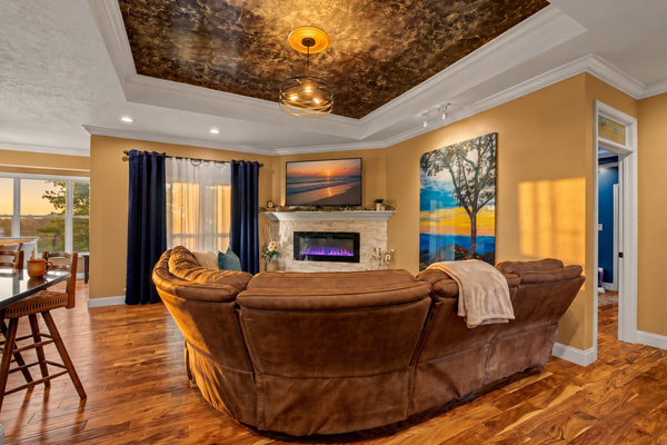 Living room with electric fireplace, big sectional, smart TV and open flow to the kitchen