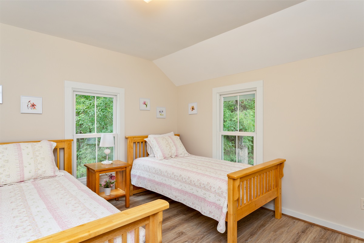 Cozy twin bedroom with fresh décor and wooded views, offering comfort and tranquility for guests of all ages. Bedroom #3 double twins