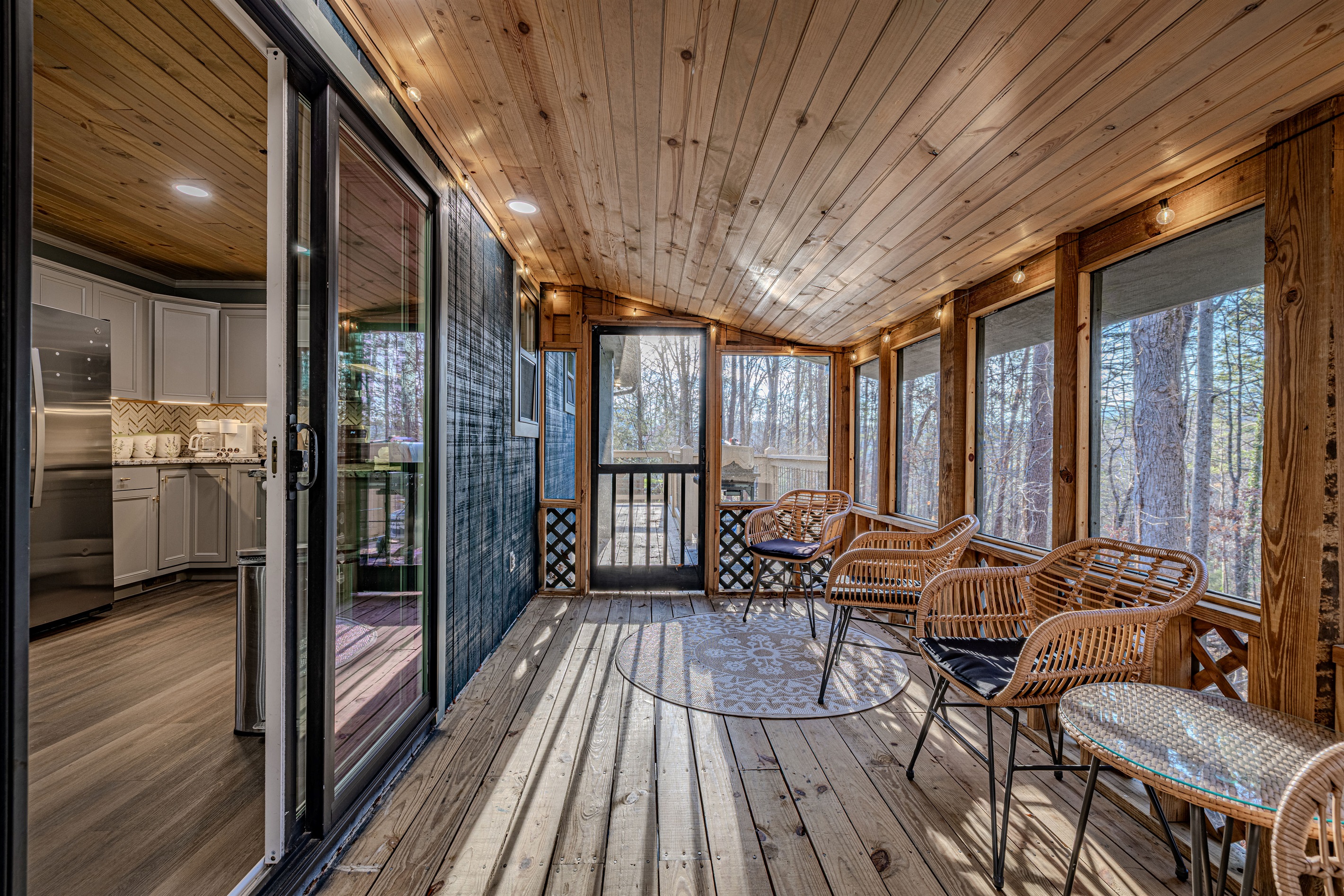 Enjoy the beauty of the forest without the elements in this fully screened porch, designed with mid-century flair and natural textures.