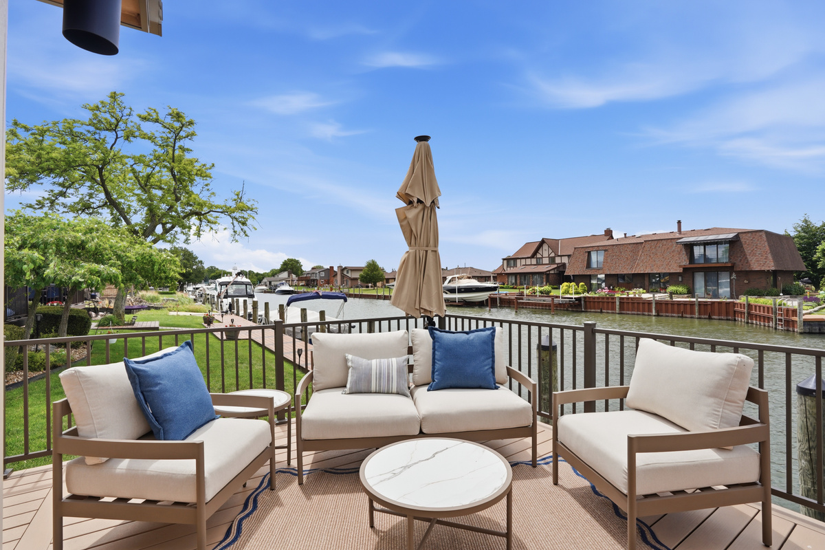 Relax on this private waterfront patio overlooking a peaceful canal. Enjoy comfortable lounge seating, umbrella shade, and serene water views—perfect for morning coffee or sunset drinks. A quiet, upscale outdoor retreat just steps from the water.