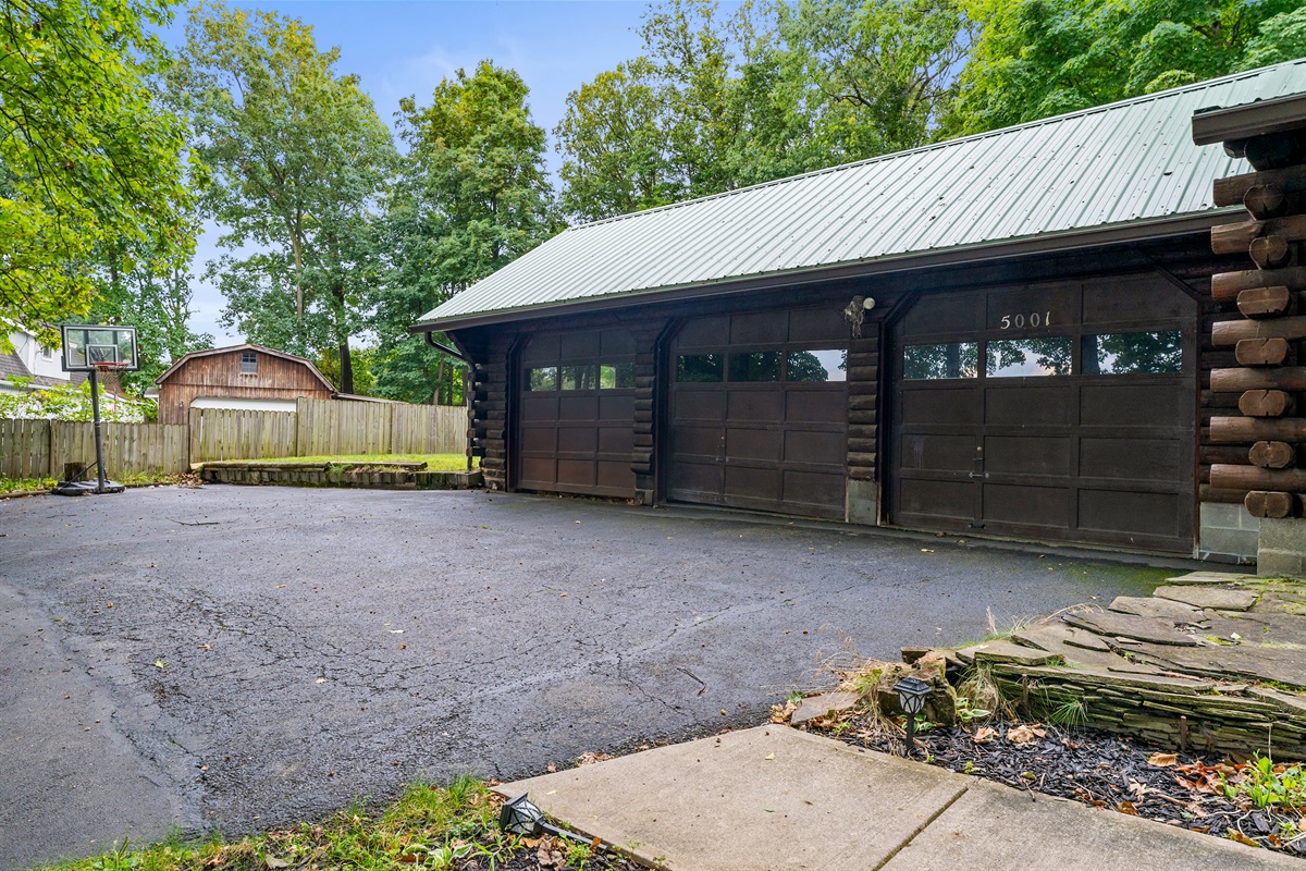 A wide driveway with basketball hoop and large garage offers both fun and convenience.