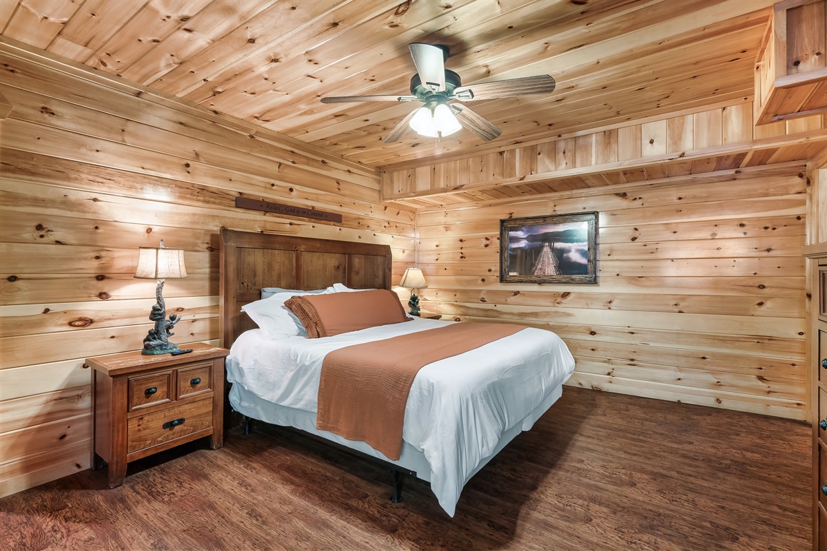 Drift off in a rustic wood paneled bedroom where cozy textures and cabin charm make sleep come easy