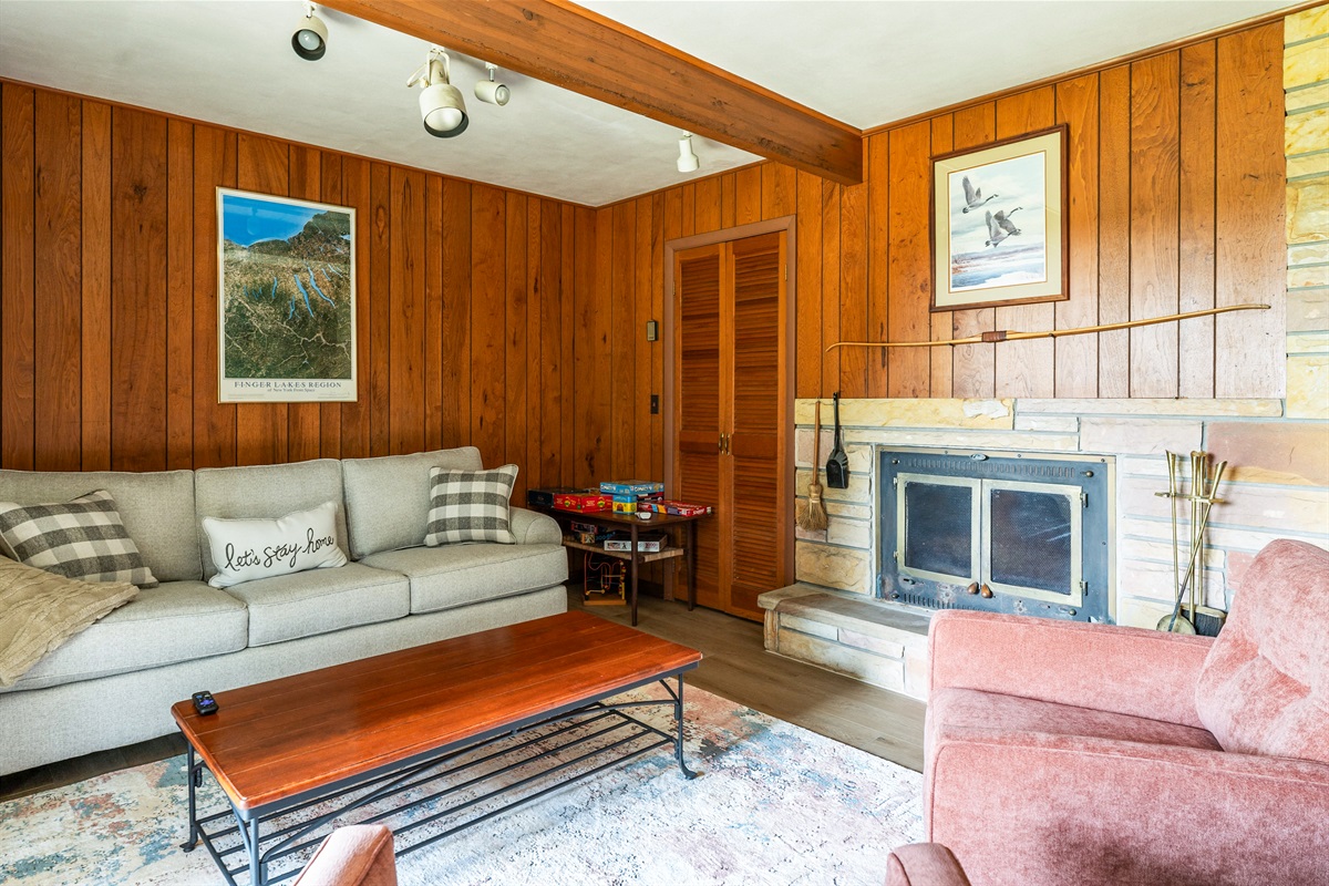 Rustic charm meets comfort with a stone fireplace, spacious sofa, and a collection of board games—ideal for unwinding after a day of adventure.