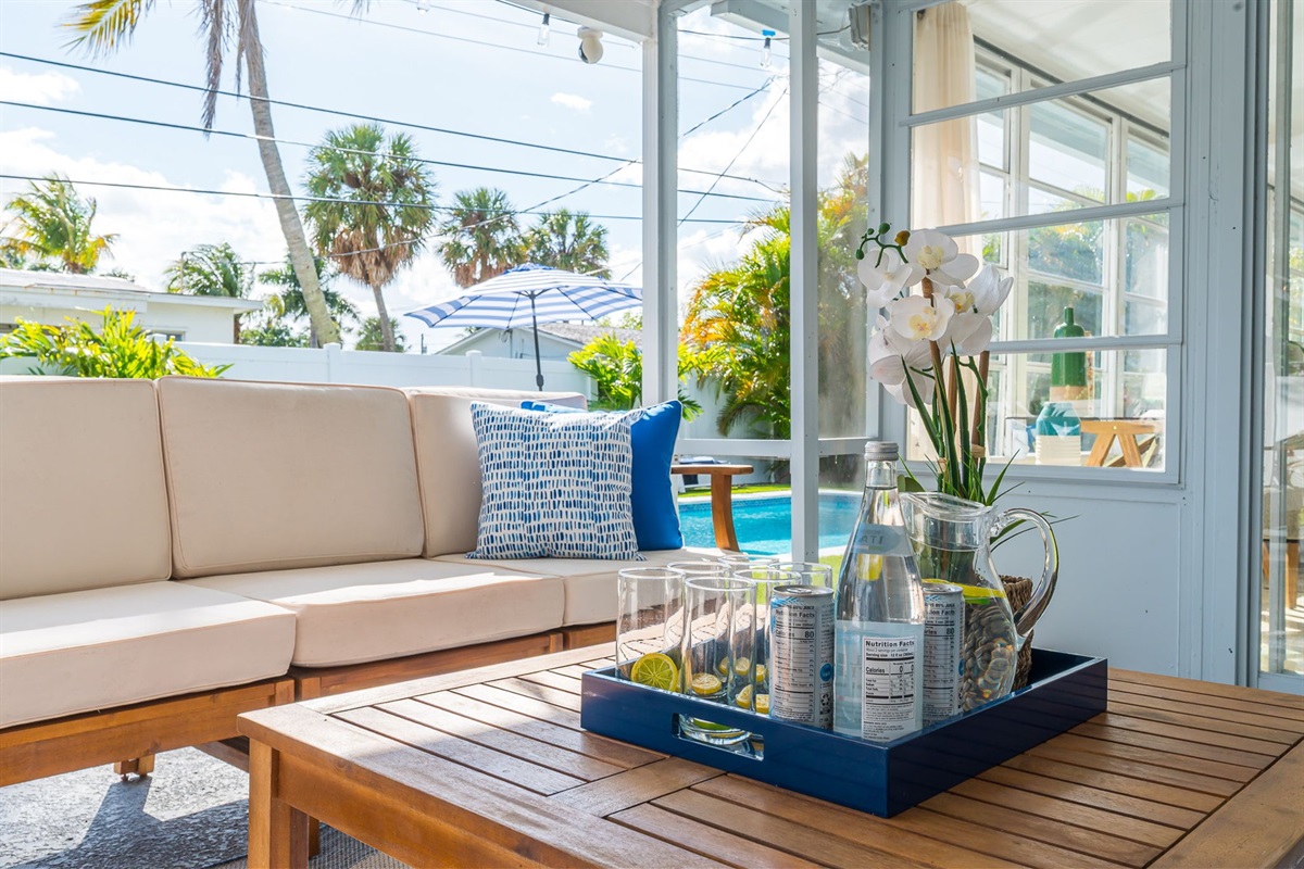 A serene covered patio with chic seating, alfresco dining, a gas grill, and a two-person hammock, all framed by a mix of manicured turf and lush lawn—your private outdoor retreat.