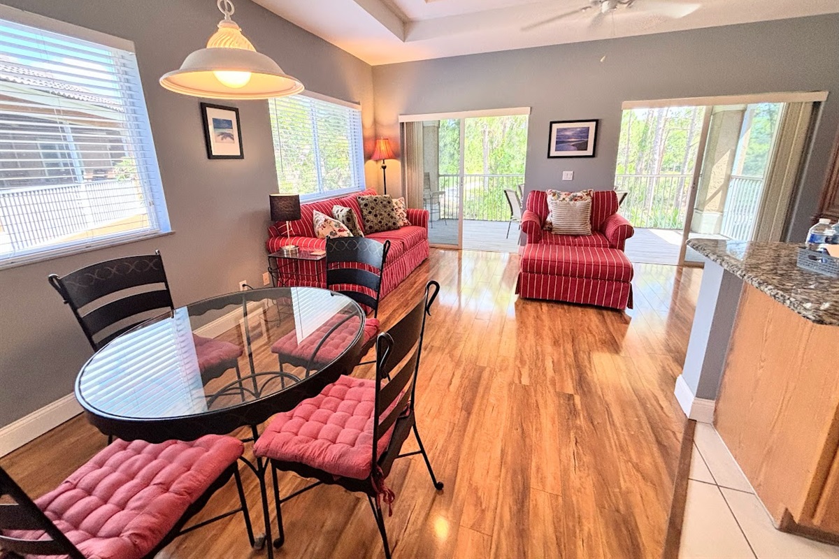 Spacious living and dining area with large windows, natural light, and an open layout perfect for relaxing or entertaining.
