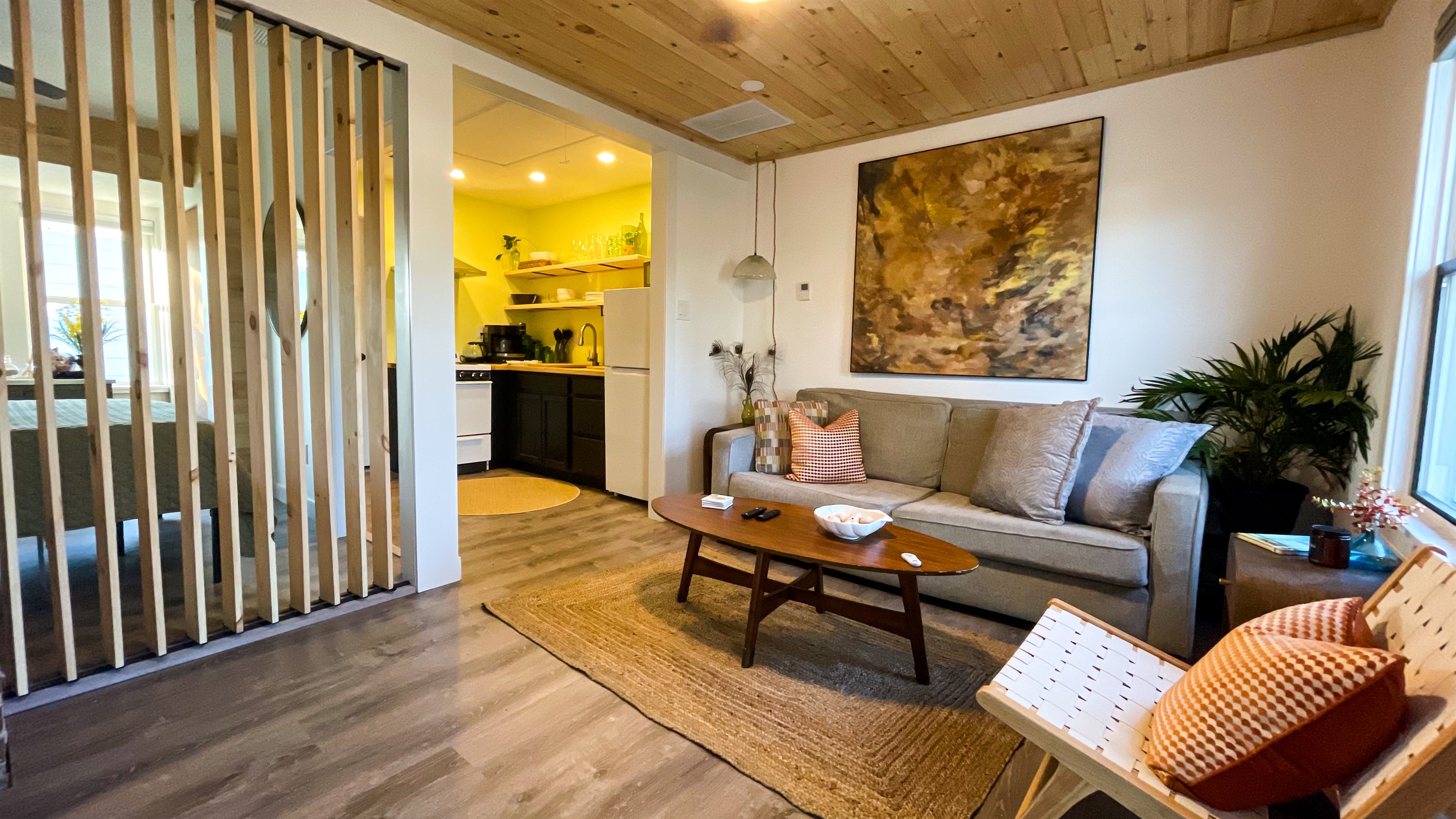 The wooden slat wall in the living room opens and closes for light and privacy