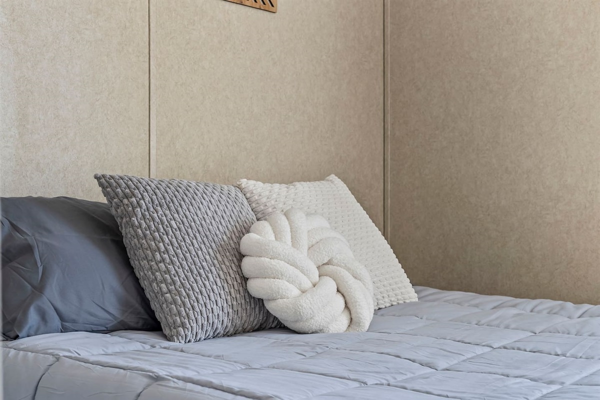 Stylish close-up of the bed with modern accent pillows and soft linens designed for comfort and relaxation.