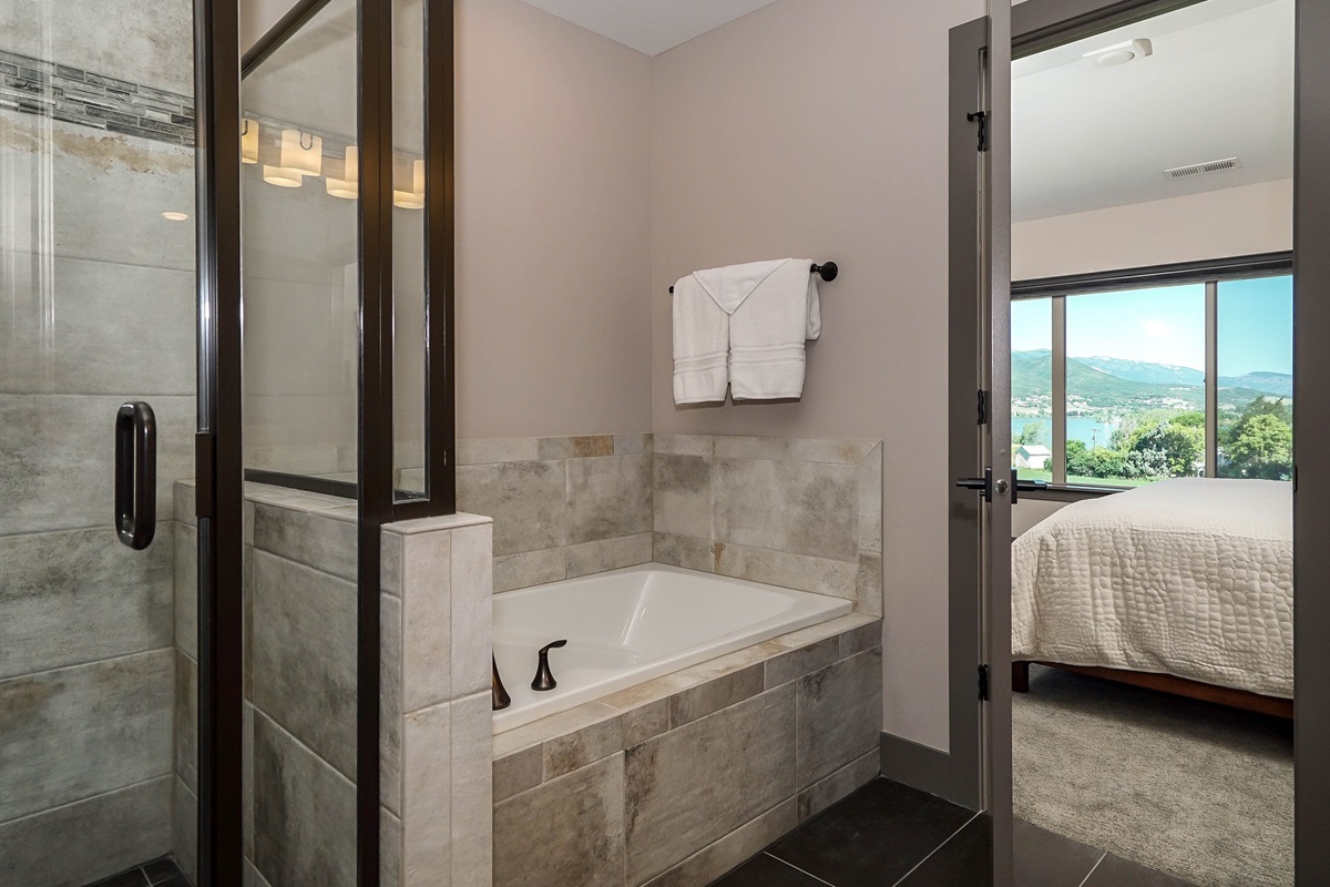 Spa-like primary bathroom with soaking tub and glass shower.