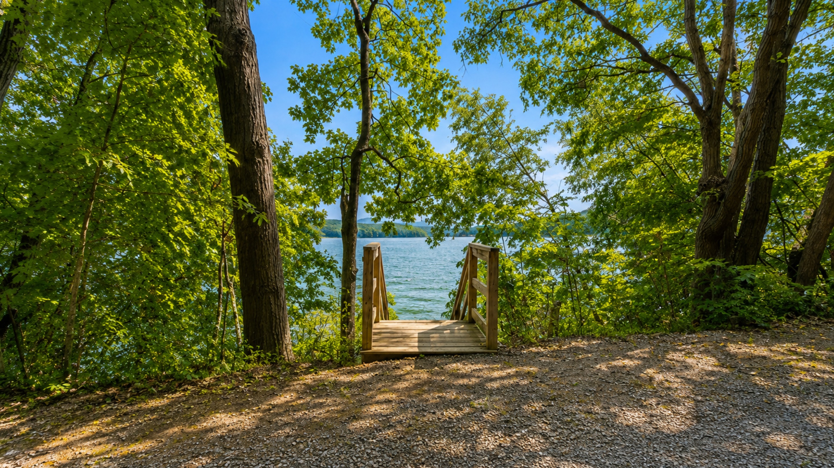 A charming woodland entrance guides you down to the sparkling lake, blending nature with relaxation.