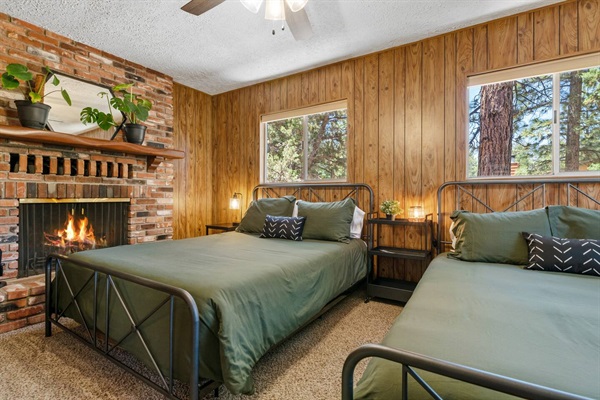 Our third bedroom is located upstairs and includes two queen size beds and a wood-burning fireplace