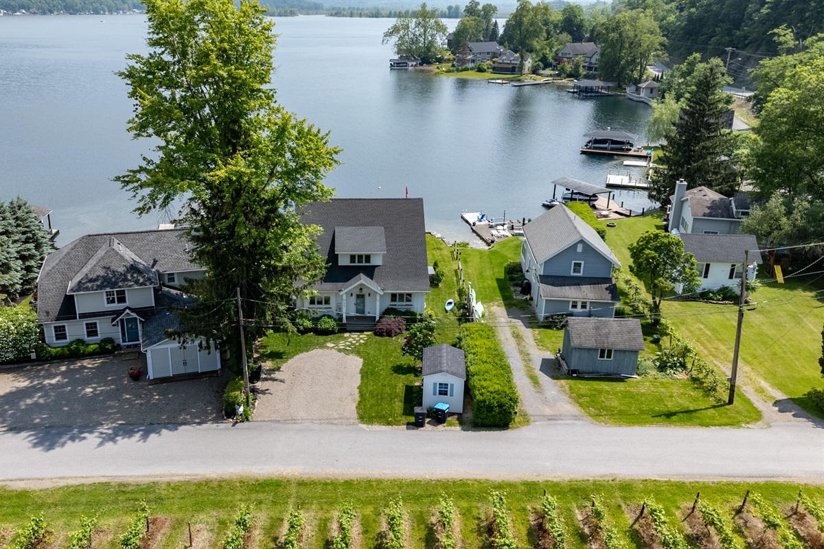 Stunning aerial view of a serene Finger Lakes waterfront retreat, complete with private dock, lush greenery, and charming lakefront homes—perfect for peaceful getaways and water adventures