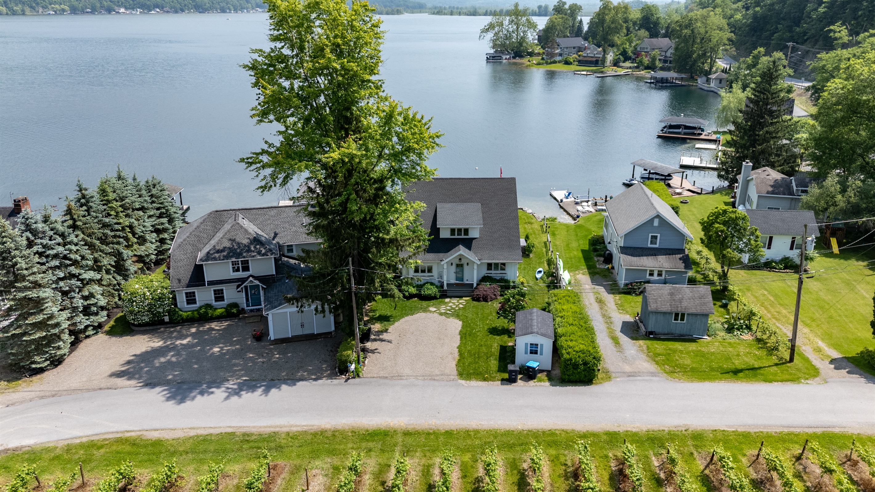 Stunning aerial view of a serene Finger Lakes waterfront retreat, complete with private dock, lush greenery, and charming lakefront homes—perfect for peaceful getaways and water adventures