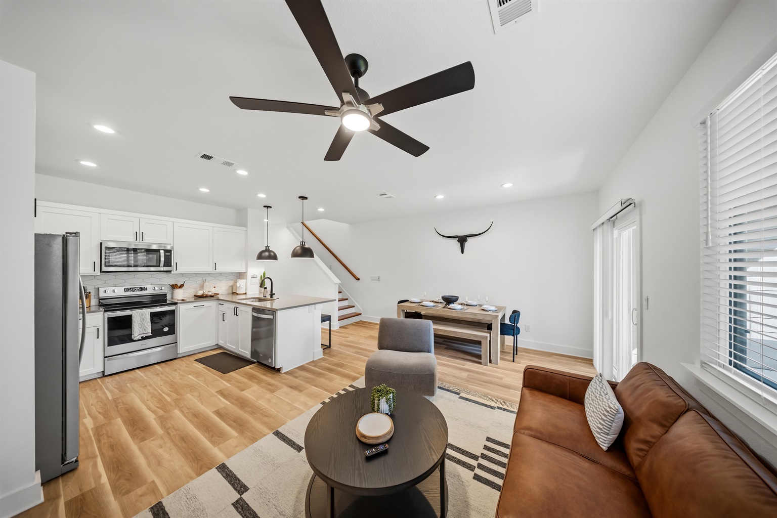 Kitchen and living area designed for easy group gathering with dining space and patio access.