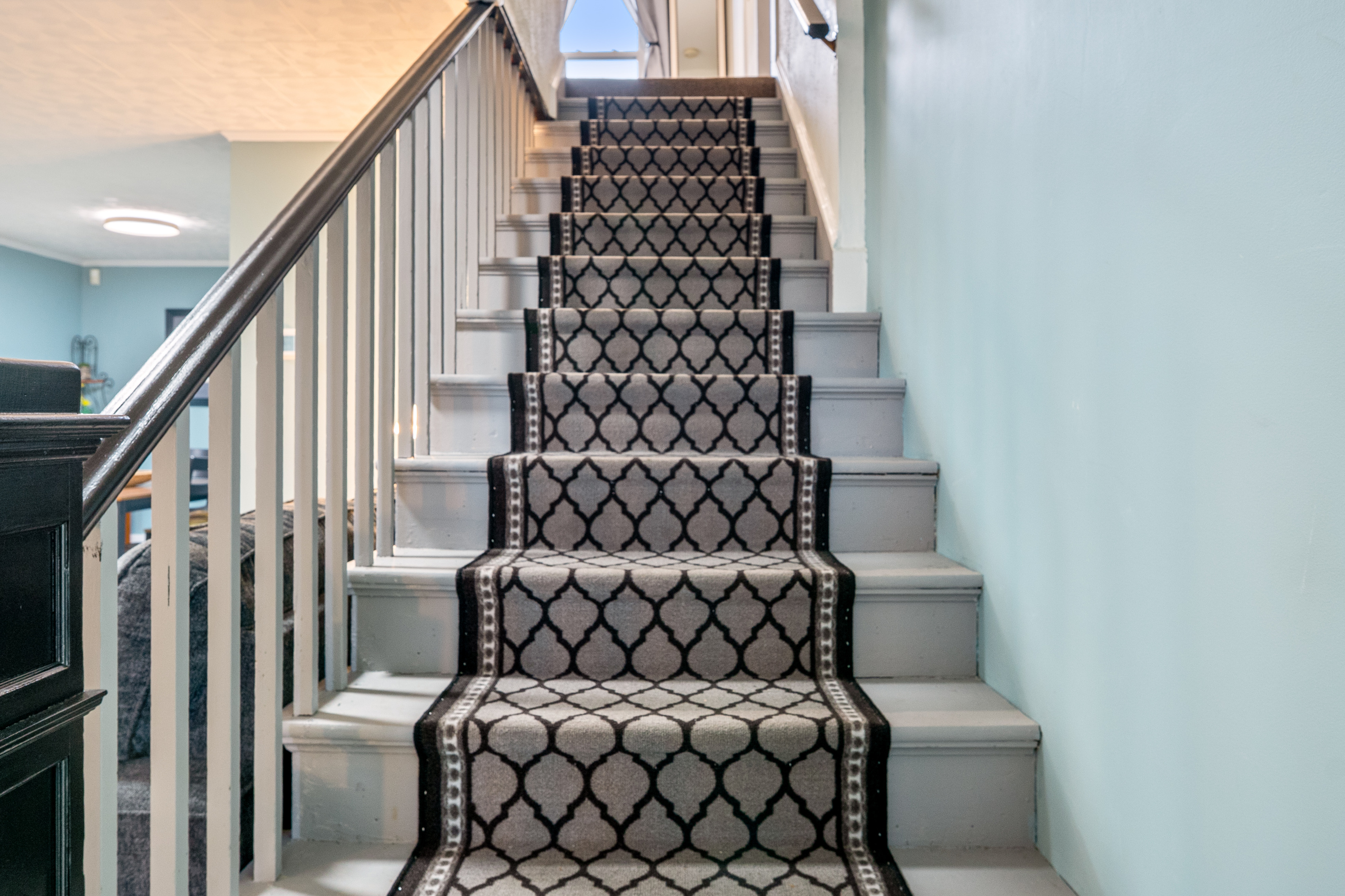 Head upstairs to the private sleeping quarters. Our main staircase features a stylish geometric carpet runner designed to muffle footsteps and provide secure footing, helping early risers move around easily without waking the rest of the house.