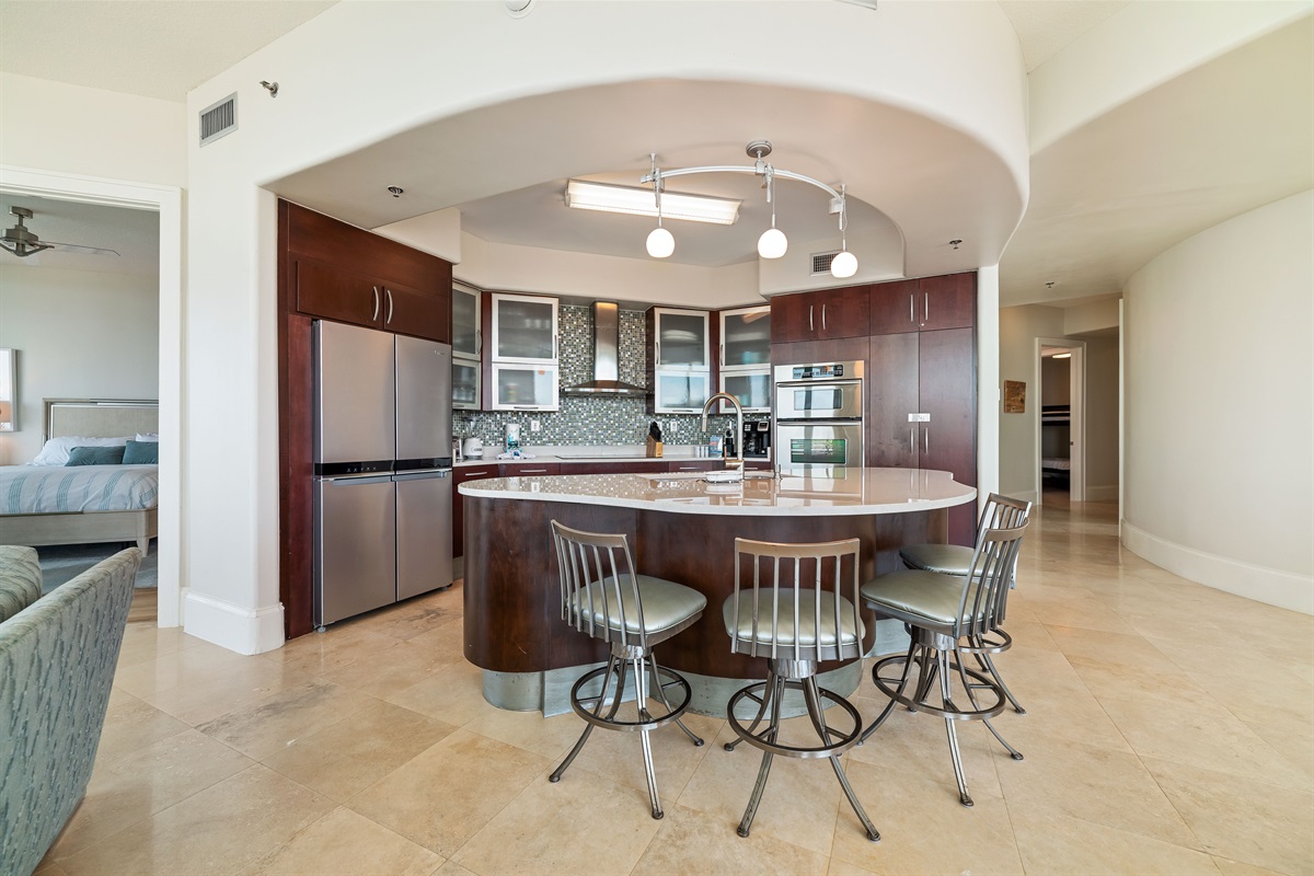 The modern kitchen island with bar seating offers a casual dining option, while the open layout maximizes natural light and showcases the stylish finishes throughout.