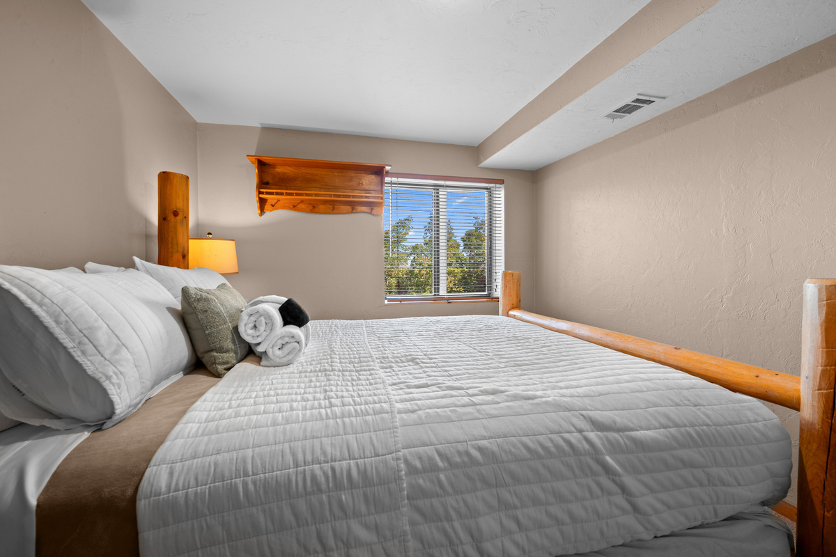 Bright queen bedroom downstairs with mountain views through the window.