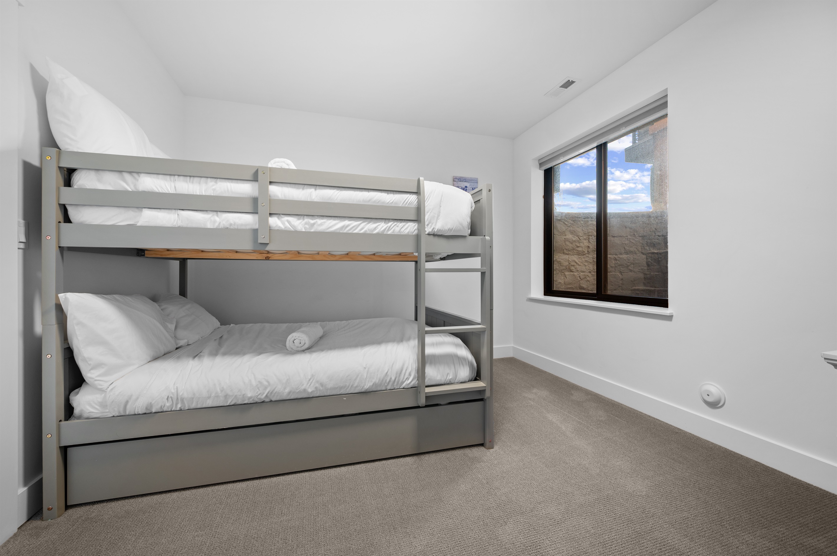 Lower-level bunk room with queen-over-queen bunk bed and twin trundle.