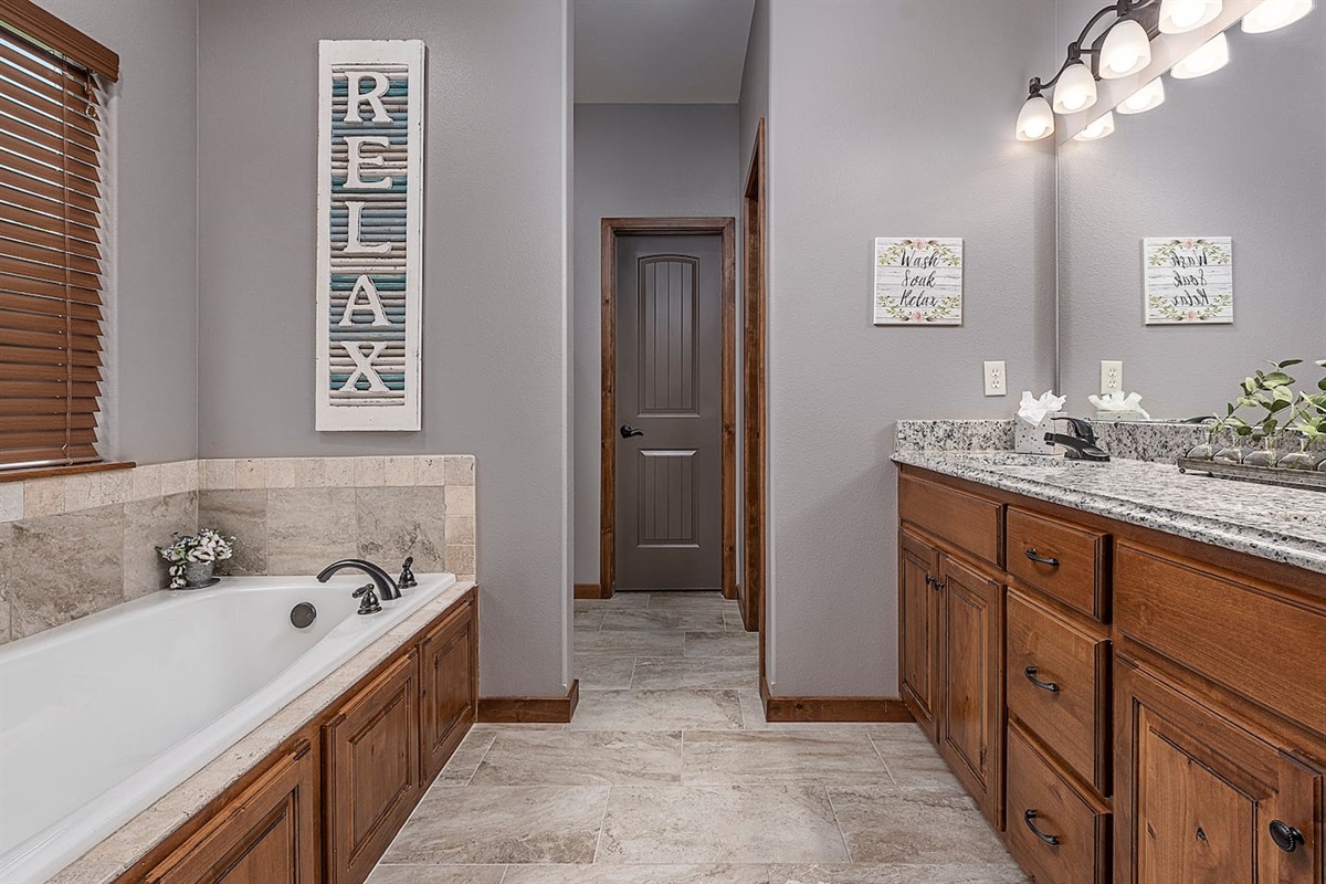 Main Level Primary Suite Bathroom w/Soaking Tub, Dual Vanity, toilet, shower, and walk in closet