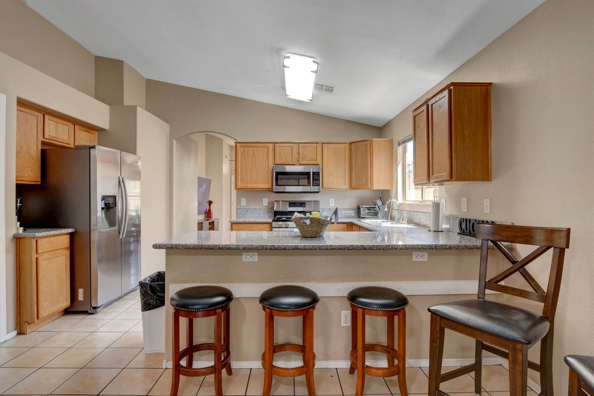 Spacious kitchen with granite bar, 4 stools & stainless appliances