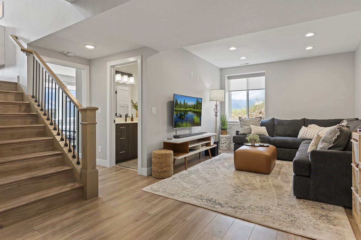 Spacious living room with cozy sectional, staircase access, and modern mountain style