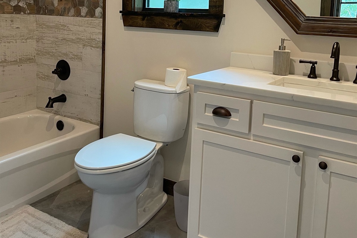 The upstairs bathroom contains a large vanity with plenty of counter space as well as lots of storage behind the cabinet doors.