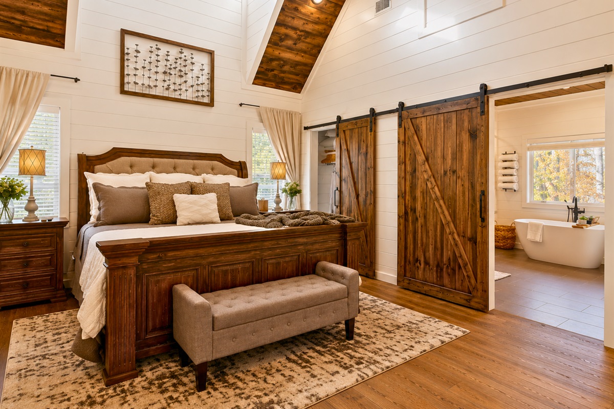 Sliding barn doors, rustic finishes, and soft neutral tones create a warm and relaxing retreat within the bedroom suite.