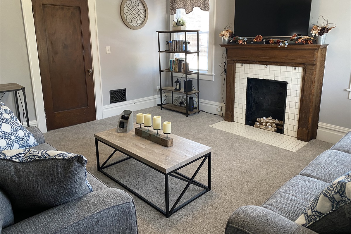 The smart tv is above the decorative fireplace.