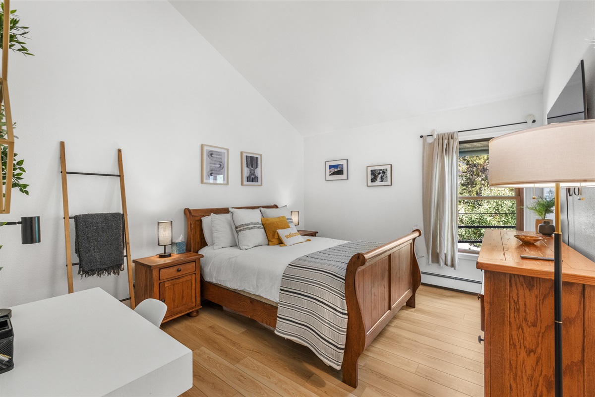 Bedroom 1, with 1 queen bed and wall mounted TV