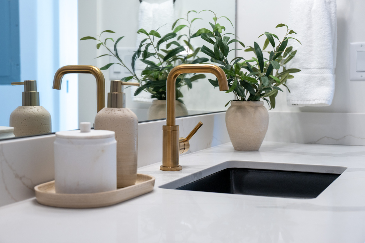 Close-up details highlight the bathroom’s warm brass fixtures and polished contemporary design.