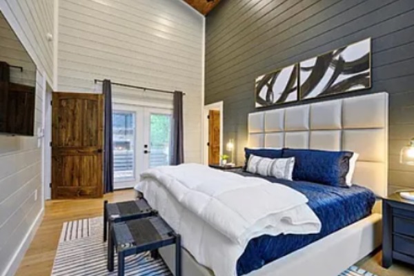 King bedroom with plush bedding and contemporary design.