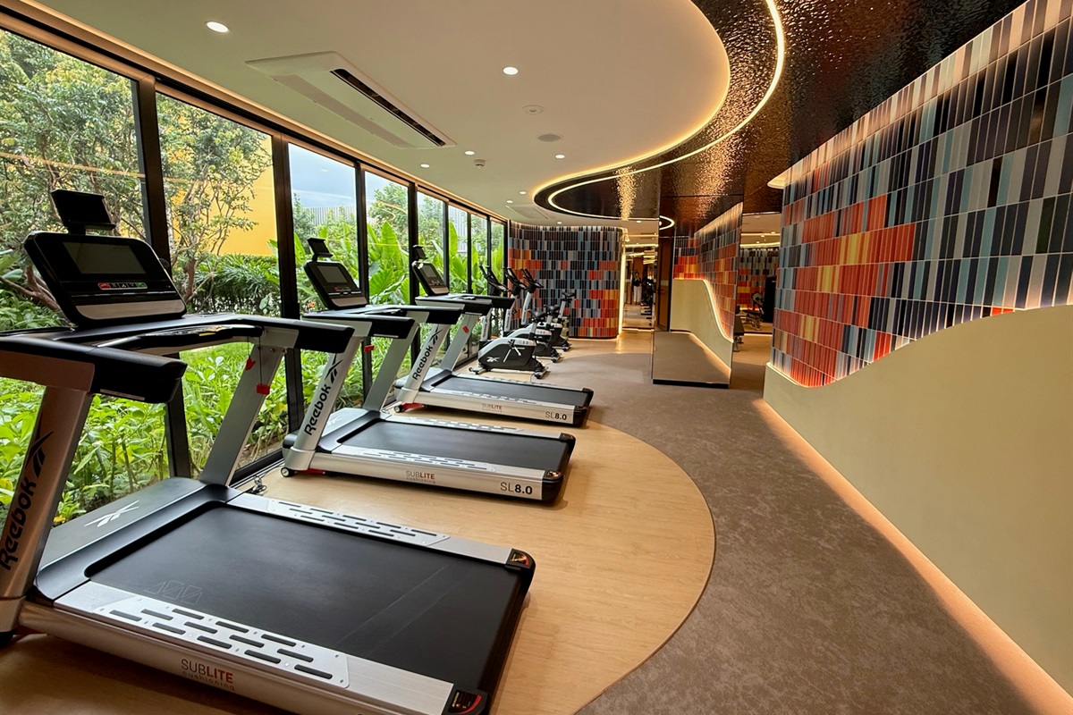 Enhance your workout—whether strength training or cardio—with an underwater-themed space featuring coral murals and garden views.