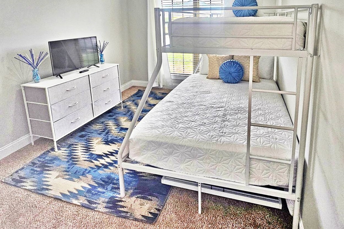 This serene bedroom can sleep up to 4 adults. Full-length mirror and flat screen smart TV in here as well!
Full-size bed and 2 twin beds. 1 twin bed is a trundle located under the bunk. 