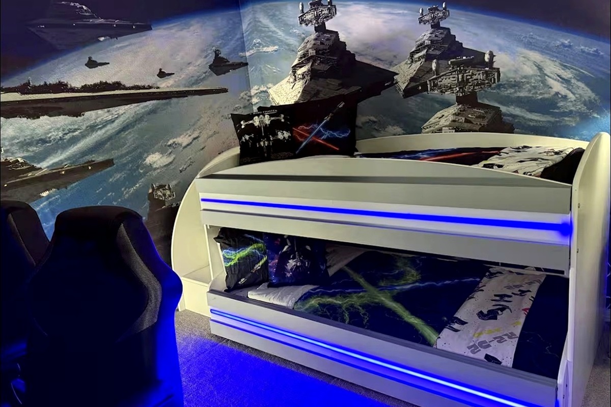 A space-themed bedroom featuring a bunk bed with blue LED lighting and a galactic wall mural.
